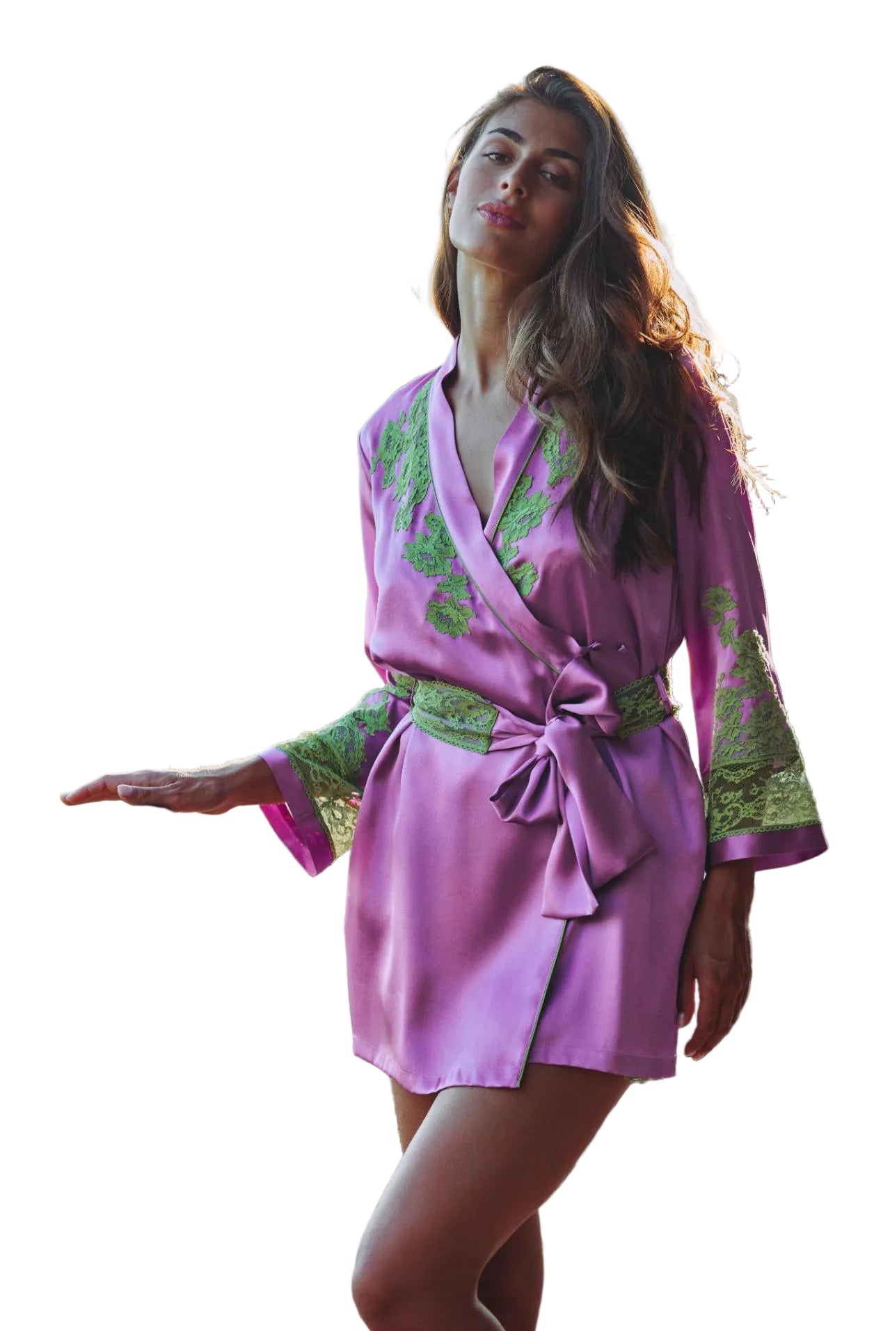 A woman wearing a purple silk-like robe with green floral embroidery and a matching tie belt, standing on an outdoor balcony with a blurred mountain background.