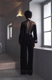 Rear view of model showing sheer lace back panel on Marjolaine dark velvet wrap jacket available at BLUE SALON.