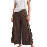 Model shot featuring the Meimeij brown wide-leg culotte trousers paired with a simple white t-shirt, emphasizing the relaxed structural fit and tactile floral embellishments.