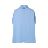 Back view of the Meimeij cornflower blue blouse showcasing the clean cape structure and the elegant vertical keyhole cutout at the neckline, available at BLUE SALON shop.