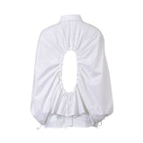 Rear studio presentation of the Meimeij white shirt, detailing the architectural open-back oval cutout, heavy surrounding pleats, and adjustable drawstring tie.