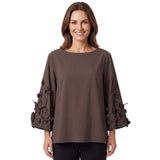 Front view of a smiling model wearing the Meimeij chocolate brown 3D floral applique blouse styled with tailored dark trousers from BLUE SALON shop.