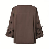 Back view of the Meimeij brown blouse showcasing the back yoke panel with a crisp inverted center pleat and dimensional sleeve details, available at BLUE SALON shop.