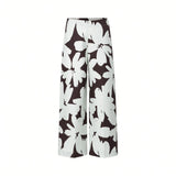 Front view of Meimeij high-waisted wide-leg trousers featuring a bold, oversized dark brown and white floral print and a clean flat-front waistband against a white background.