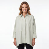 Front view of a smiling model wearing the Meimeij oversized sage green button-down shirt paired with dark trousers.