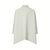 Back view of the Meimeij sage green blouse showcasing its fluid drape, relaxed shoulders, and the sharp pointed lines of the high-low hemline, available at BLUE SALON shop.