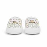 Directly overhead bird's-eye view of a pair of infant Michael Kors slip-on shoes, showing the tan interior lining with gold printed branding and white elastic laces.