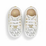 Front view of a pair of off-white Michael Kors infant shoes, showing white laces, gold metallic eyelets, and a shiny gold-tone MK monogram lace lock hardware piece.