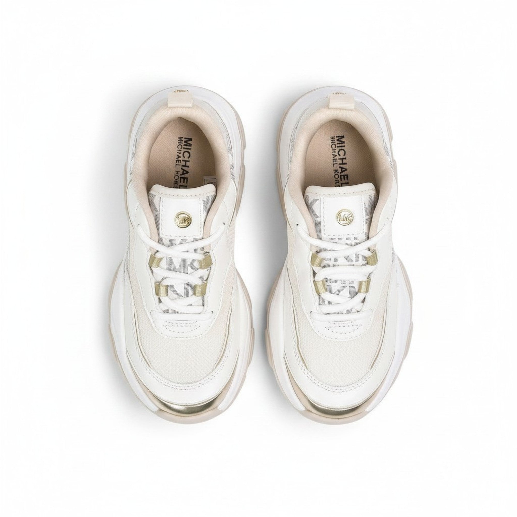 Directly overhead bird's-eye view looking inside a pair of kids' Michael Kors shoes, displaying the tan interior insoles with gold printed branding and clean white lacing.