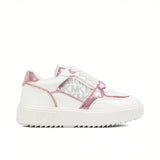 Side profile view of a white Michael Kors low-top sneaker featuring a thick platform sole, woven MK monogram fabric side panels, and shimmery metallic pink leather trim overlays.