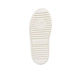 Underneath view of the off-white rubber outsole of a Michael Kors sneaker, highlighting a ribbed horizontal tread pattern and a large circular MK logo centered in the middle.