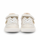 Straight front-facing view of a pair of kids' white and grey trainers, highlighting a breathable mesh toe box, clean white laces, and a circular metallic MK logo on the tongues.