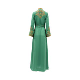 Back view of the emerald green Mijade Fashion gown showing a gold embroidered floral motif on the upper back and a smooth, flowing floor-length skirt.