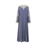 Back view of a slate blue long-sleeved modest dress by Mijade Fashion showing the embroidered neckline and flowing floor-length hem.