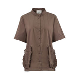 Front studio shot of the brown Milva Mi short-sleeve blouse shown unbelted, emphasizing the mandarin collar, covered button placket, and side ruffled pockets.