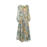 Front studio shot of a multicolor Milva Mi chiffon maxi dress featuring a watercolor tropical palm print, tiered skirt, and matching waist tie.