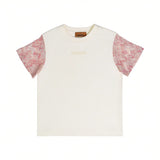 Front close-up of the Missoni kids cream crewneck T-shirt, highlighting the tonal embroidered brand logo on the chest and the pink patterned knit short sleeves.