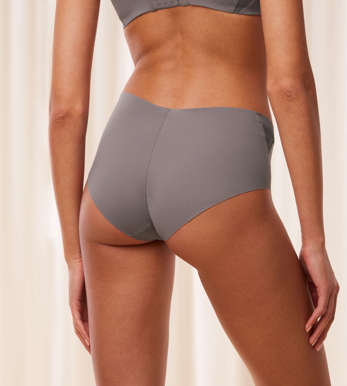 Model back view of the Triumph Flex Smart Grey maxi panty, highlighting the high-waisted fit and smooth, seamless construction. Find Online Today