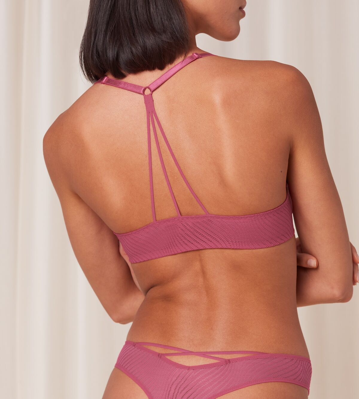 Model back view of the Triumph Harmony Spotlight push-up bra in Pink, showcasing the intricate lace and back design. Shop Now Online