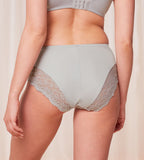 Model back view of the Triumph Ladyform Soft light grey maxi panty, highlighting the high-waisted fit and delicate lace side inserts. Find Now Online
