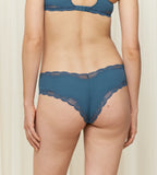 Model back view of the Triumph Natural Spotlight blue hipster panty, showing the low-rise fit and flat lace detailing at the legs. Shop Now Online