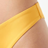 Model close-up view of the Triumph Flex Smart Summer saffron yellow Brazilian bikini bottoms, highlighting the high-leg cut and seamless edges. Available Online