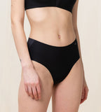 Model front view of the Triumph Flex Smart black maxi panty, highlighting the high-waisted coverage and smooth, seamless fabric. Available Online at Blue Salon Qatar