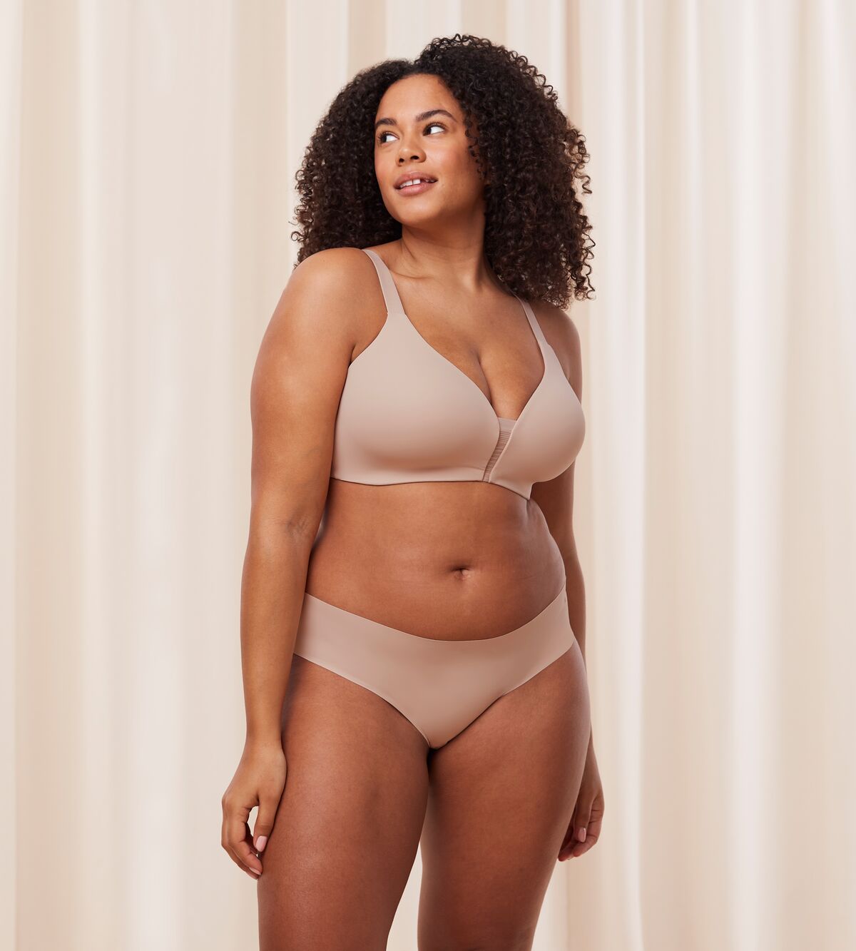 Model full front view of the Triumph Fit Smart beige non-wired bra, highlighting the stretchable lace design and wireless comfort construction. Available Online Now
