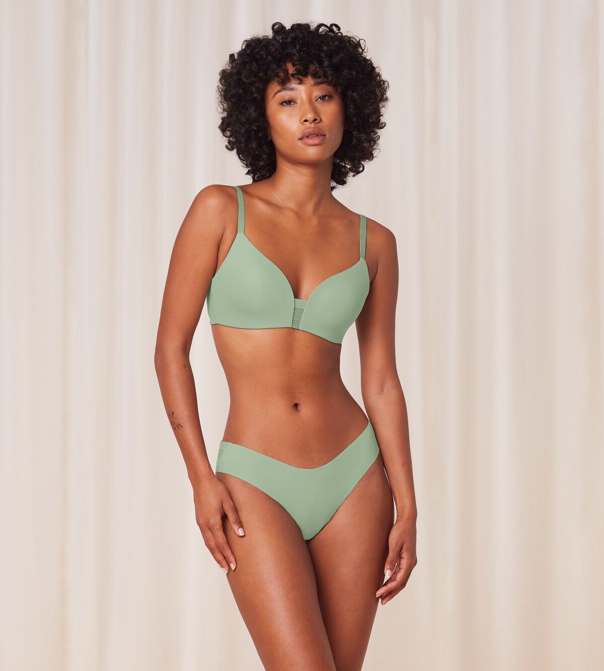 Model full front view of the Triumph Flex Smart green high-leg Brazilian panty, showcasing the smooth elastic fabric and modern silhouette. Now Available Online