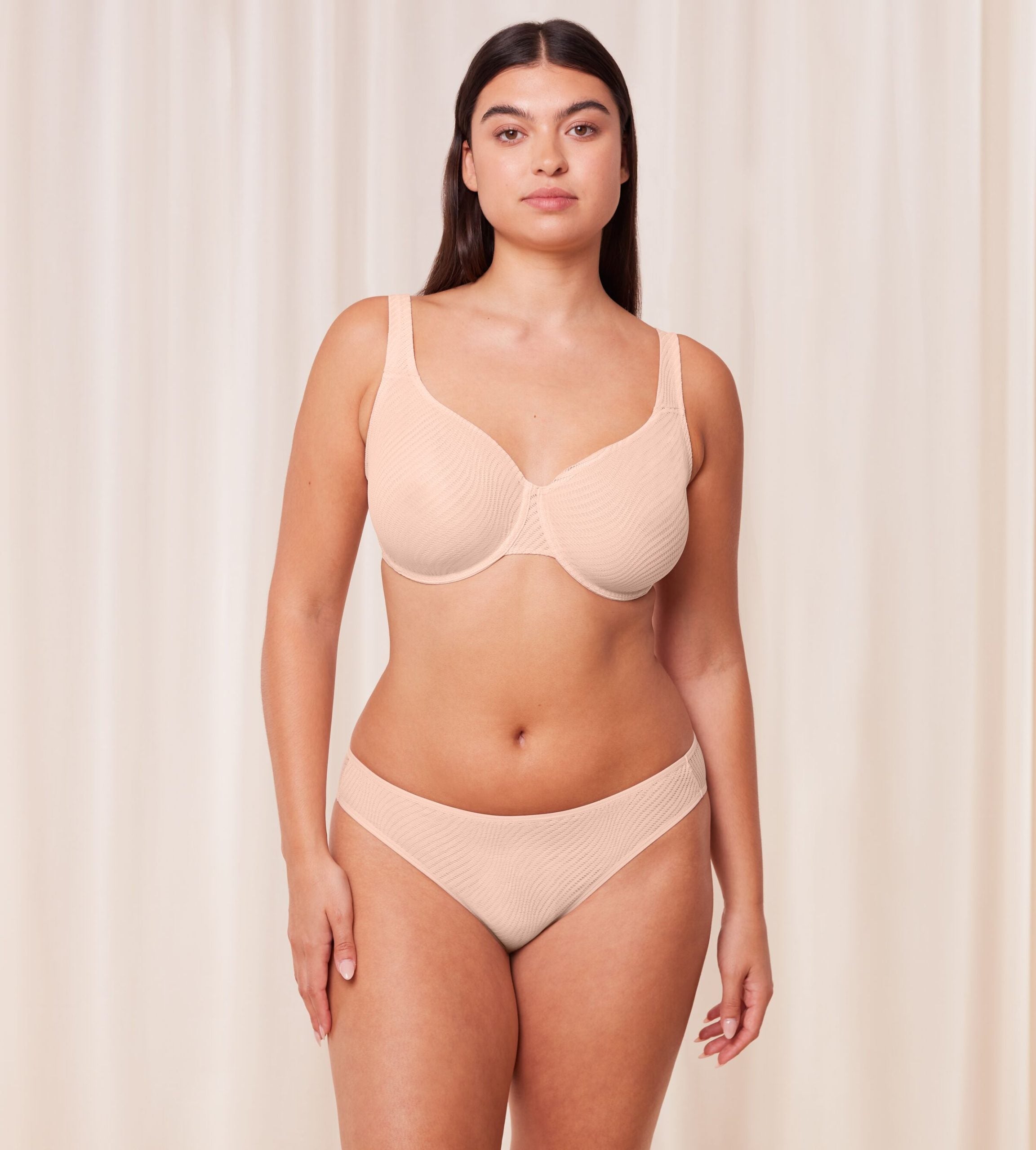 Model full front view of the Triumph Harmony Spotlight Fig Pink Tai panty, showcasing the sheer graphic lace and classic high-leg silhouette. Find Online Today