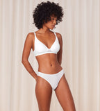 Model full front view of the Triumph Harmony Spotlight white Tai panty, showcasing the intricate graphic lace and flattering high-leg silhouette. Available Now Online