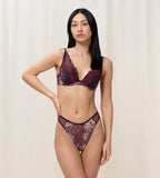 Model full front view of the Triumph Lavish Spotlight burgundy high waist thong, showcasing the intricate lace embroidery and sheer mesh details. Now Available Online