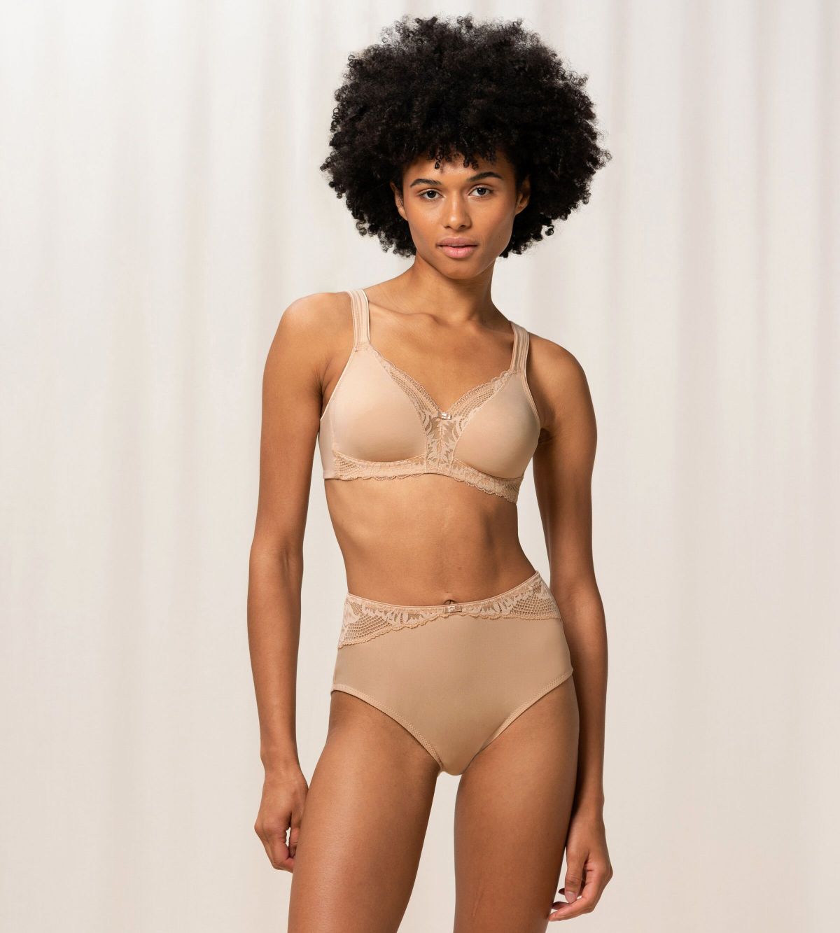 Model full front view of the Triumph Modern Lace+Cotton beige non-wired bra, showcasing the cotton cups and decorative floral lace. Shop the Latest Online