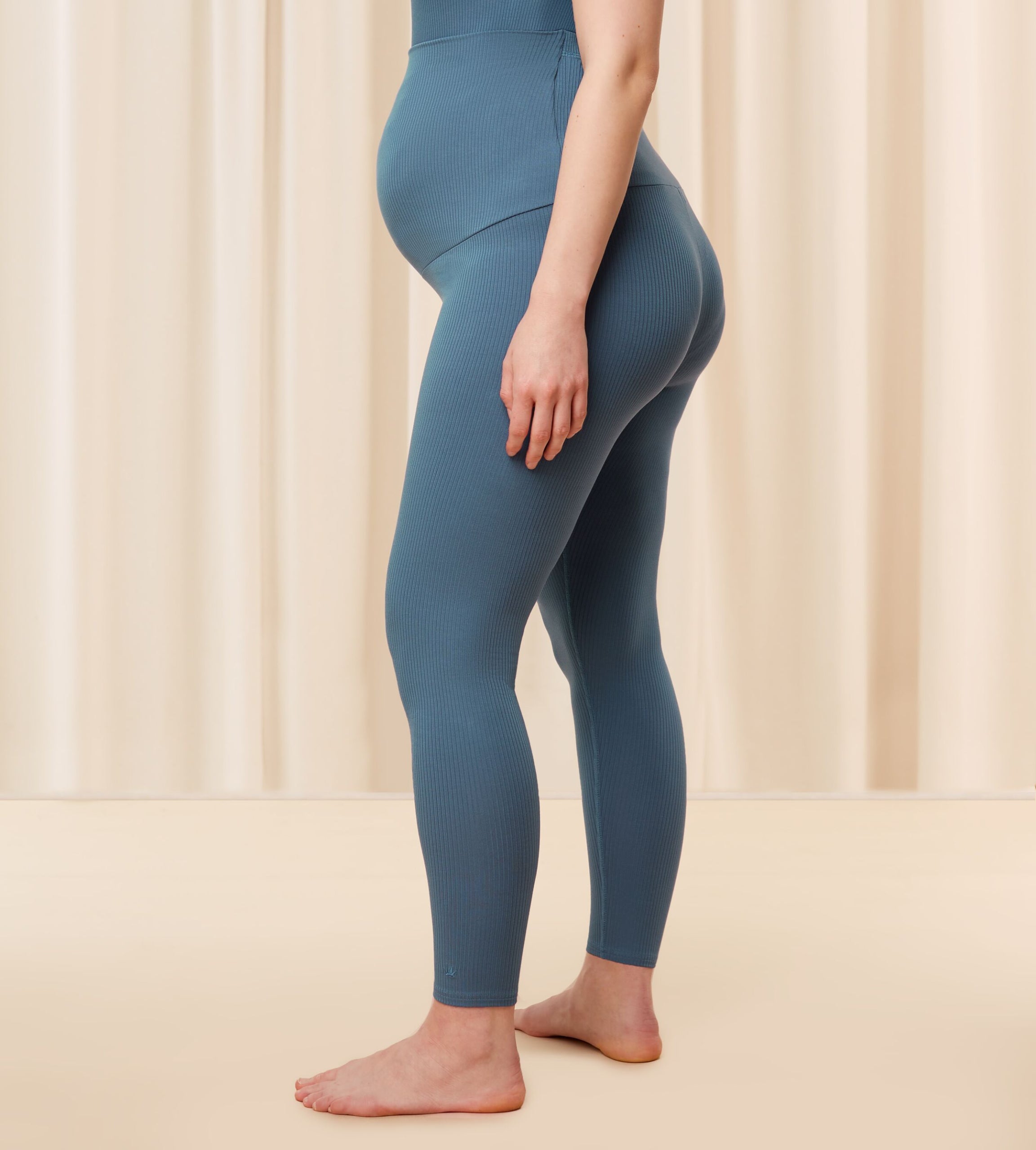 Model second side view of the Triumph Natural Spotlight blue rib comfort stretch trousers, highlighting the pregnancy-friendly waistband and wide-leg cut. Shop Online