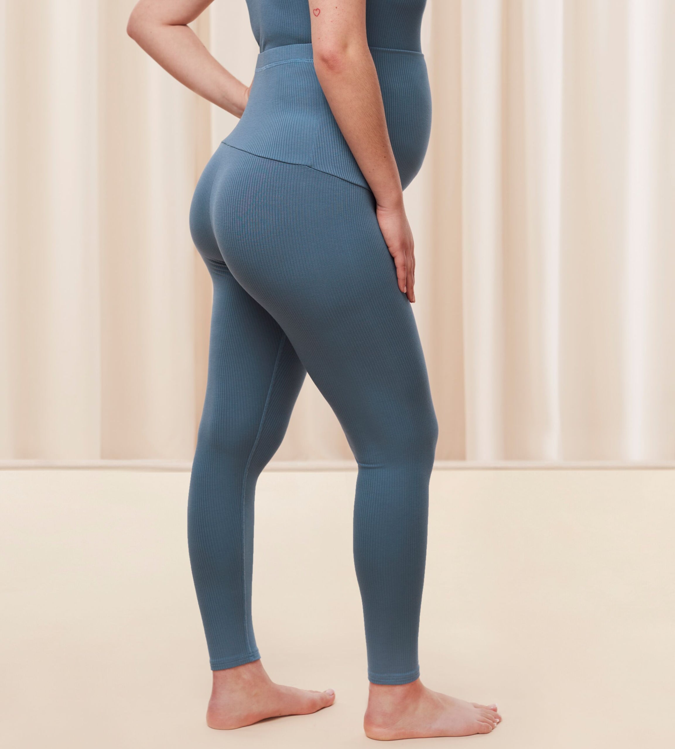 Model side view of the Triumph Natural Spotlight blue rib comfort stretch trousers, highlighting the pregnancy-friendly waistband and wide-leg cut. Shop Online