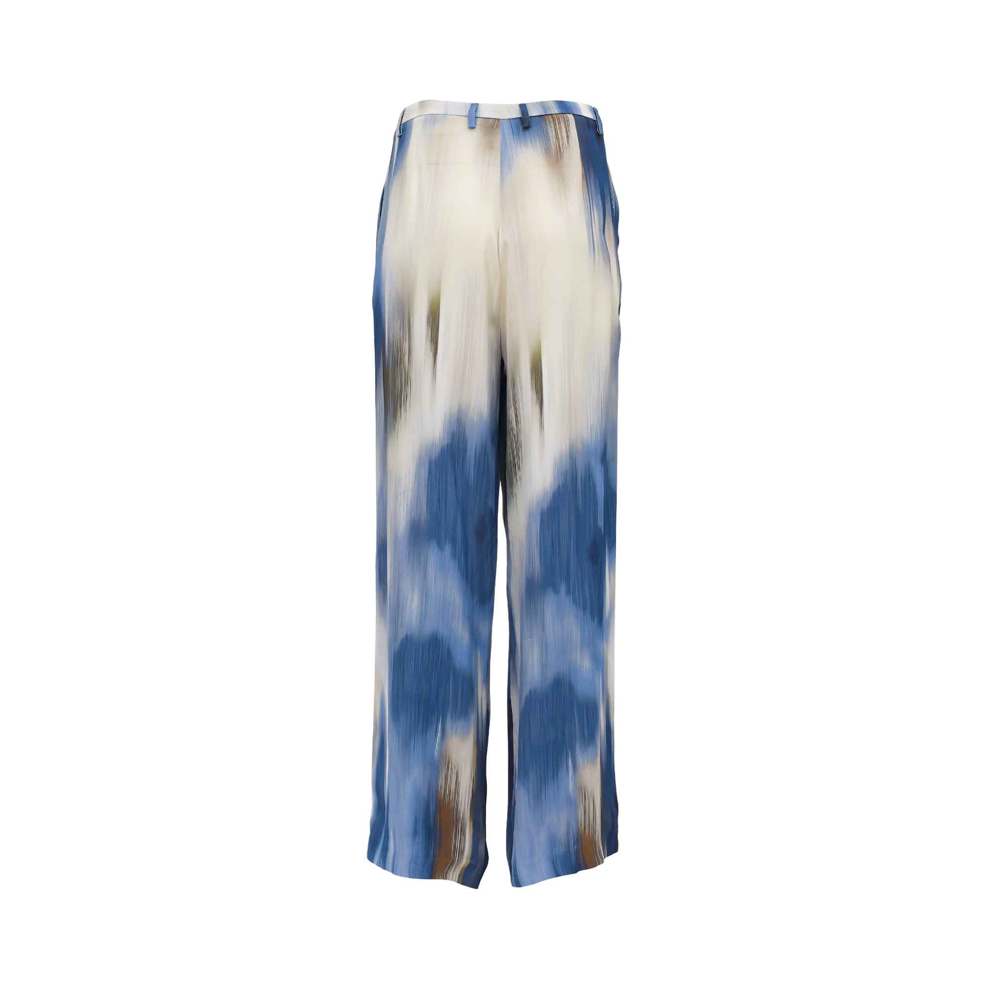 Back view of the Momonì fluid wide-leg pants, highlighting the vertical gradient of the blue, cream, and brown abstract brushstroke print and the clean tailoring at the seat.