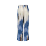 Back view of the Momonì fluid wide-leg pants, highlighting the vertical gradient of the blue, cream, and brown abstract brushstroke print and the clean tailoring at the seat.