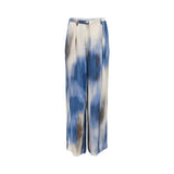 Front view of a pair of women's Momonì wide-leg trousers featuring a blue and cream abstract watercolor tie-dye print, detailed with front pleating, belt loops, and a single-button waistband closure.