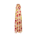 Front view of a Momoni halter maxi dress featuring a vibrant watercolor floral print in pink and red with a large decorative bow at the neckline.
