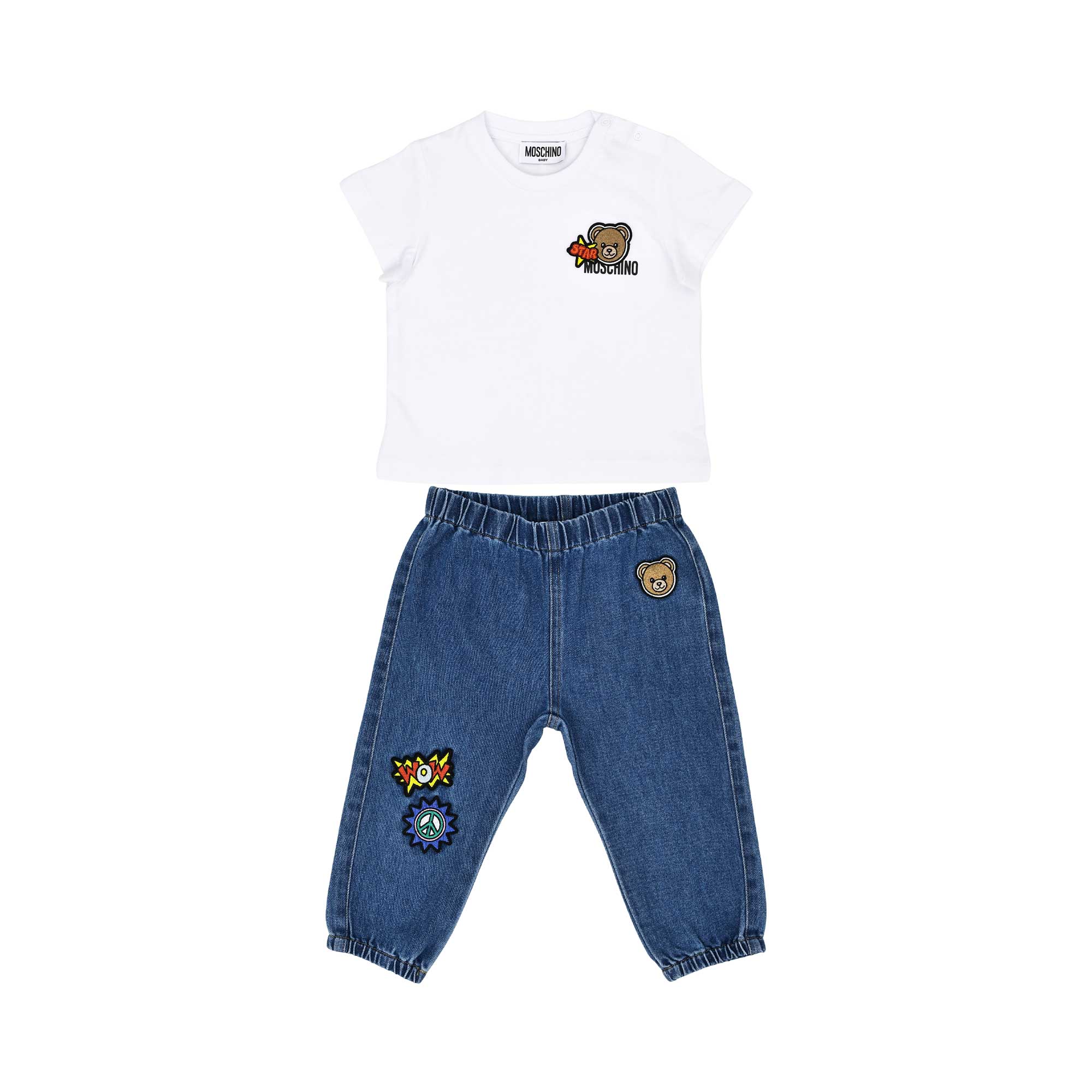 A baby's designer outfit featuring a white T-shirt with a star teddy patch and blue denim joggers with colorful graphics.