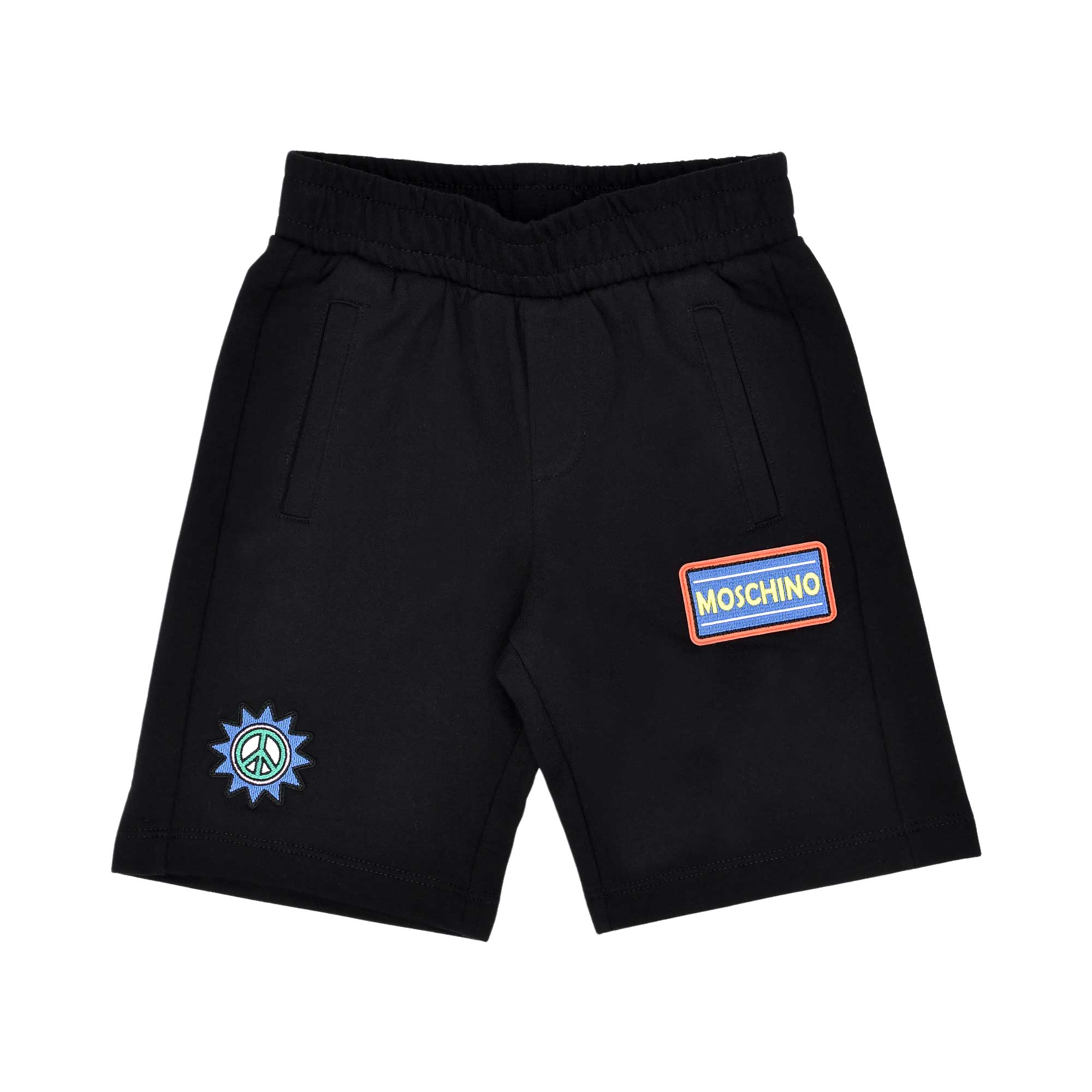Close-up of the black jersey shorts featuring a colorful logo patch and peace sign embroidery.