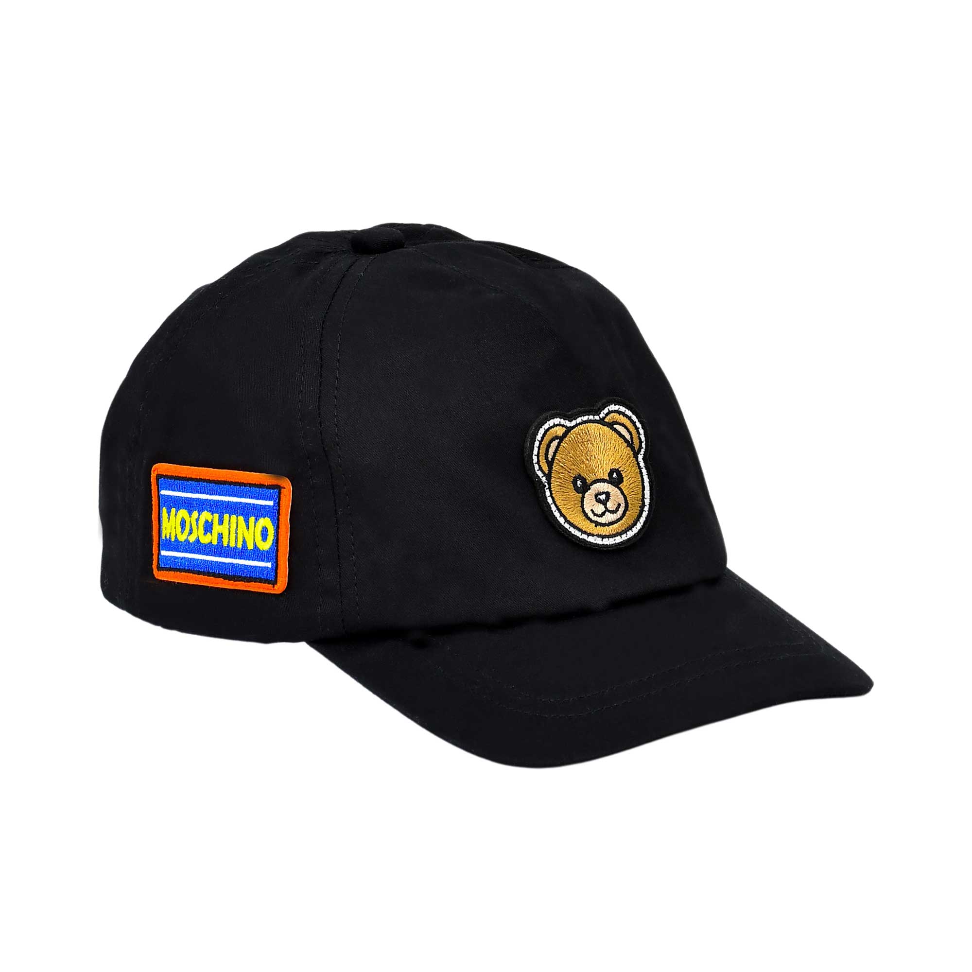 Angled view of a black Moschino cap showing the Teddy Bear patch on the front and the blue and yellow Moschino logo patch on the side.