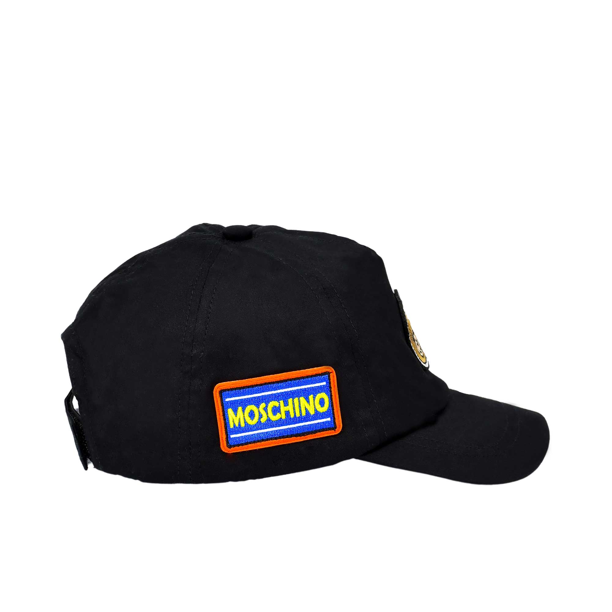 Side profile of the black cotton cap highlighting the rectangular Moschino brand patch with an orange border.