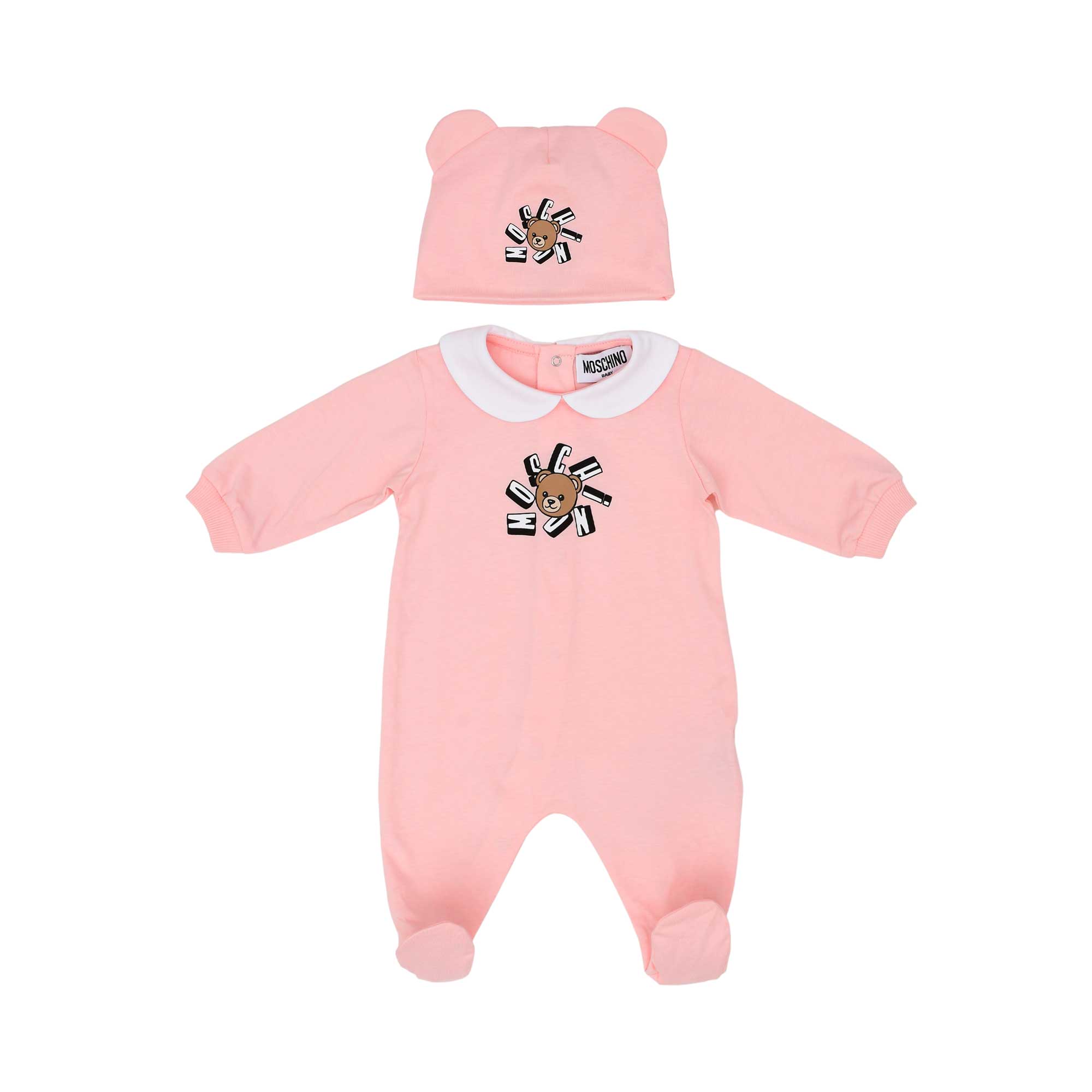 Front view of a pink Moschino Kids babygrow with a Peter Pan collar and a matching white hat with bear ears, both featuring the Teddy Bear logo