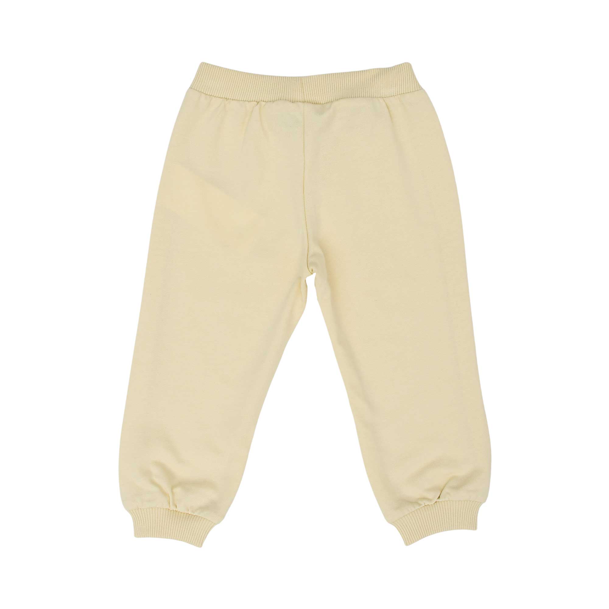 Back view of the cream joggers showing the Teddy Bear patch on the upper left leg and ribbed ankle cuffs.