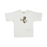 Front view of the white Moschino T-shirt showing the Teddy Bear mascot on a green surfboard.