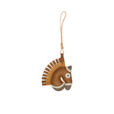 A handcrafted leather bag charm by MUNI shaped like a horse's head. The charm features a brown leather face, a layered fringe mane in alternating tan and ochre, and a cream-colored leather loop for attachment against a white background.
