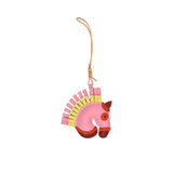 A handcrafted leather bag charm by MUNI shaped like a horse's head. The charm features a brown leather face, a layered fringe mane in alternating tan and ochre, and a cream-colored leather loop for attachment against a white background.