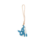 A handcrafted blue and white leather whale charm by MUNI, featuring white contrast stitching and a tan leather hanging loop, isolated on a white background.