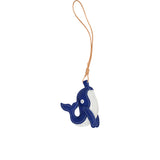 A handcrafted blue and white leather whale charm by MUNI, featuring white contrast stitching and a tan leather hanging loop, isolated on a white background.